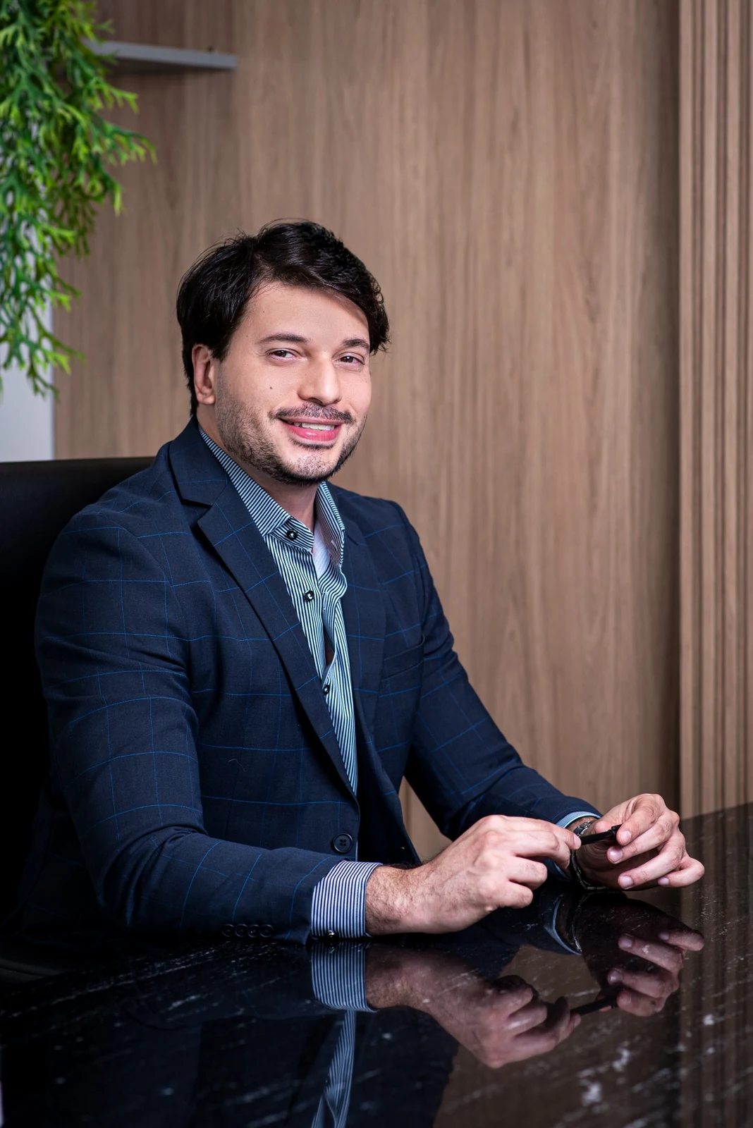 Dr. Rossini Monteiro sorrindo à mesa do consultório.